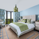Colourful bedroom with scallop jute rug Matouk bedding and blue and green lantern with Thibaut drapery Florida coastal living