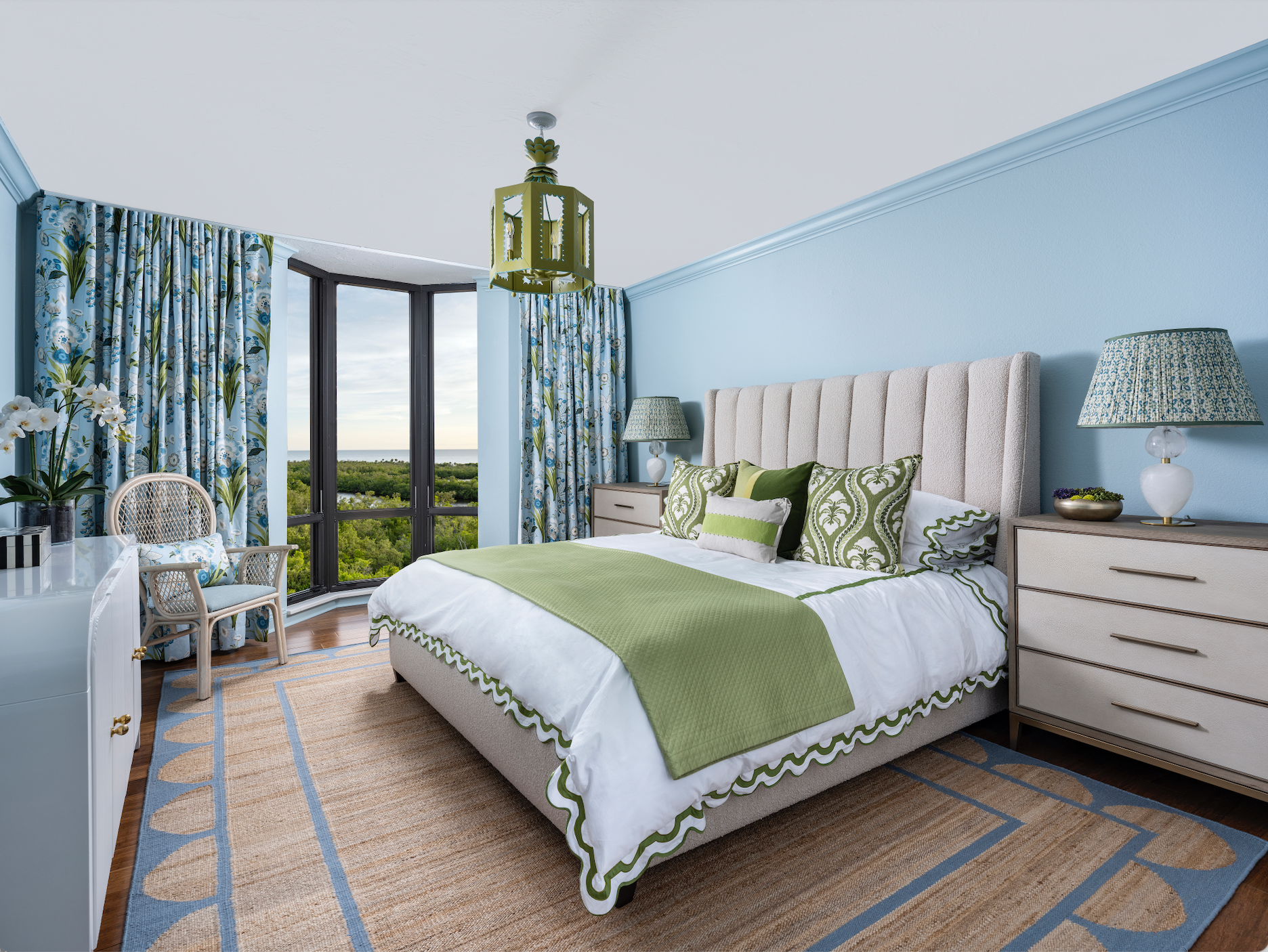Colorful bedroom with Matouk bedding and green and blue home decor accents Thibaut drapery and scallop edge rug